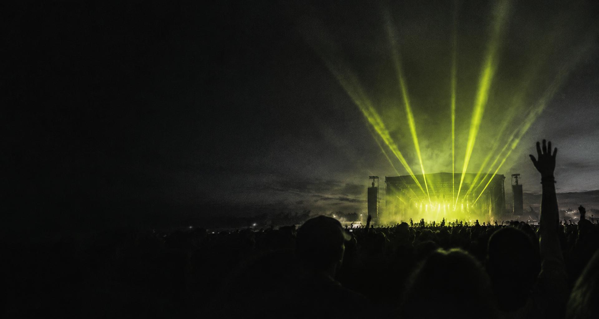 A festival crowd beneath electric-lime stage lights